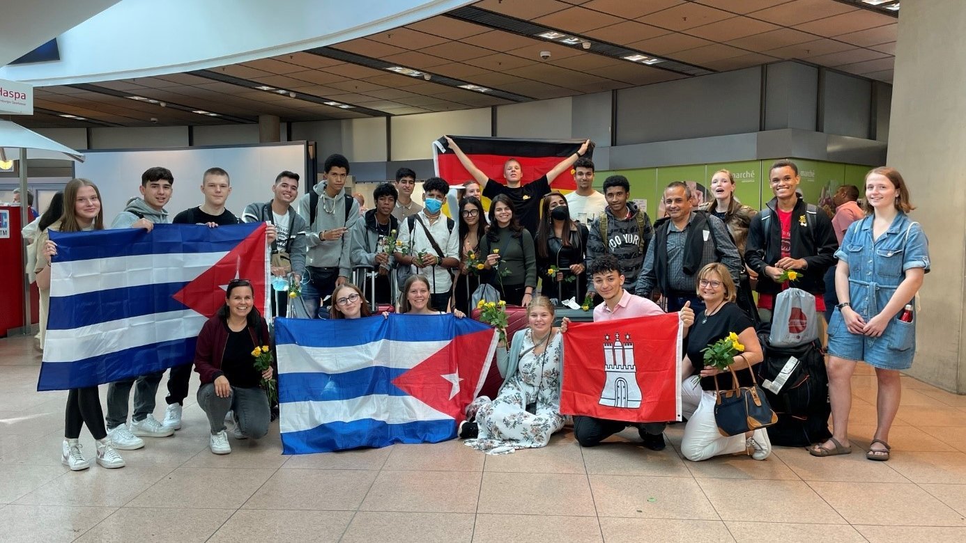 Gruppenbild von deutschen und kubanischen Schülerinnen und Schülern mit den Flaggen von Deutschland, Kuba und Hamburg